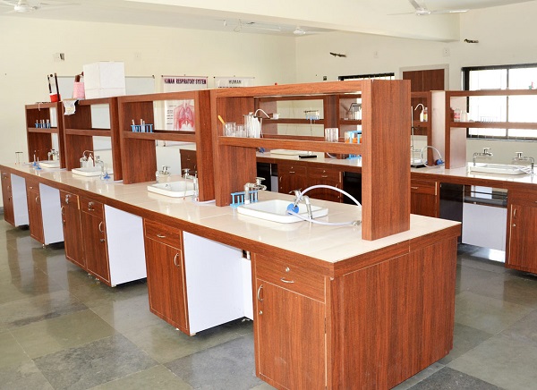 A science lab with tables, shelves, equipment and sinks.